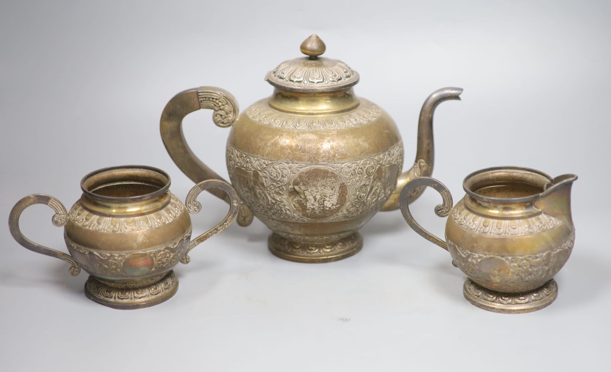 A Ceylonese white metal three piece tea set, teapot height 19.5cm,